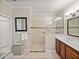 Bright bathroom features a glass shower, neutral tile, vanity with double sinks, and decorative elements at 13209 Palmilla Cir, Dade City, FL 33525