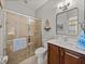 Bright bathroom featuring tiled shower, wooden vanity, and decorative touches for a fresh and inviting space at 13209 Palmilla Cir, Dade City, FL 33525