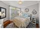 A bright bedroom features a bed with decorative pillows and blankets, a patterned rug, and window views at 13209 Palmilla Cir, Dade City, FL 33525