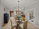 Bright dining area features a glass table, chandelier, and flows into the kitchen for easy entertaining at 13209 Palmilla Cir, Dade City, FL 33525