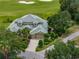 Exterior view of the house including a two-car garage, green roof, and verdant landscaping at 13209 Palmilla Cir, Dade City, FL 33525