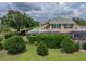 Backyard exterior view featuring a screened lanai, lush landscaping, and a well-maintained lawn at 13209 Palmilla Cir, Dade City, FL 33525