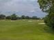 Scenic view of the golf course with manicured green fairways, mature trees, and sand bunkers at 13209 Palmilla Cir, Dade City, FL 33525