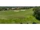 Golf course view with manicured green, sand traps, and neighborhood in the distance at 13209 Palmilla Cir, Dade City, FL 33525