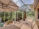 Outdoor lanai featuring comfortable seating, an umbrella, and serene views at 13209 Palmilla Cir, Dade City, FL 33525