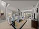 Bright living room features a white sectional sofa, coastal decor, and stairs to an upper level at 13209 Palmilla Cir, Dade City, FL 33525