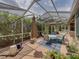 Screened-in patio with multiple seating areas and lush landscaping provides a relaxing outdoor space at 13209 Palmilla Cir, Dade City, FL 33525