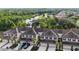 An aerial view shows the townhomes near a pond surrounded by lush green trees at 13233 Canopy Creek Dr, Tampa, FL 33625