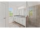 Bright bathroom features a double sink vanity with granite countertop and large tile shower at 13233 Canopy Creek Dr, Tampa, FL 33625