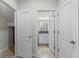 A hallway shows neutral-colored walls, white doors, and tile flooring that leads to a bathroom at 13233 Canopy Creek Dr, Tampa, FL 33625