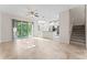 Bright living room area opens to a modern kitchen, featuring sleek tile floors and a staircase at 13233 Canopy Creek Dr, Tampa, FL 33625
