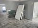 Open living room showcasing new gray flooring, fresh paint, and natural light from new windows at 14067 Marguerite Dr, Madeira Beach, FL 33708