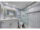 Well-lit bathroom featuring white cabinets and a glass-enclosed shower at 15000 Gulf Blvd # 602, Madeira Beach, FL 33708