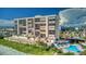 A multi-story condo building with a pool and beach access, surrounded by tropical landscaping at 15000 Gulf Blvd # 602, Madeira Beach, FL 33708