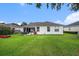 Lush green backyard featuring a well-maintained lawn and a view of the home's exterior at 1744 Brookstone Way, Plant City, FL 33566