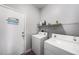 Laundry room with washer, dryer, overhead rack and access door at 1744 Brookstone Way, Plant City, FL 33566