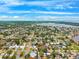 Expansive aerial view of a residential community with mature trees, streets, and waterfront access under a bright blue sky at 1810 Maryland Ne Ave, St Petersburg, FL 33703