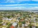 Bright aerial view of a residential neighborhood with green trees, streets, and rooftops under a beautiful blue sky with wispy clouds at 1810 Maryland Ne Ave, St Petersburg, FL 33703
