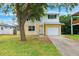 Charming two-story home featuring white and yellow siding, a well-maintained lawn, and an attached single-car garage at 1810 Maryland Ne Ave, St Petersburg, FL 33703