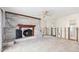 Living room with stone fireplace, tile flooring, ceiling fan, and natural light from the windows at 1810 Maryland Ne Ave, St Petersburg, FL 33703