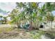 Private backyard featuring lush palm trees, outdoor seating, and a well-maintained lawn at 18198 3Rd E St, Redington Shores, FL 33708