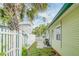 Side yard featuring white picket fence, grassy area and pathway to the backyard at 18198 3Rd E St, Redington Shores, FL 33708
