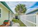 Landscaped backyard featuring a white picket fence, palm trees, and a convenient storage shed at 18198 3Rd E St, Redington Shores, FL 33708