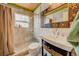 Bathroom featuring a walk-in tiled shower and a unique decorative mirror at 18198 3Rd E St, Redington Shores, FL 33708