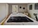 Bedroom showcasing a comfortable queen bed with black throw blanket, decor and a stationary bicycle by the window at 18198 3Rd E St, Redington Shores, FL 33708