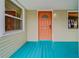 Inviting front entrance with turquoise deck and orange door, highlighted by bright sidelight at 18198 3Rd E St, Redington Shores, FL 33708