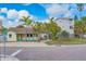Inviting coastal home with covered porch, manicured landscaping, and paved driveway entrance at 18198 3Rd E St, Redington Shores, FL 33708