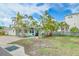 Charming home with a well-maintained front yard featuring lush palm trees and cozy outdoor seating area at 18198 3Rd E St, Redington Shores, FL 33708