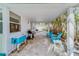 Covered patio with outdoor seating, grill, and cooler overlooking palm trees at 18198 3Rd E St, Redington Shores, FL 33708