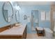 Light blue bathroom features a double sink vanity with modern fixtures and large mirrors at 243 Hermosita Dr, St Pete Beach, FL 33706