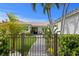 Charming single-story home featuring a well-manicured lawn, palm trees, and a welcoming walkway leading to the entrance at 243 Hermosita Dr, St Pete Beach, FL 33706