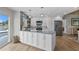 Open kitchen with white cabinets, countertops, and stainless appliances plus access to the outside at 243 Hermosita Dr, St Pete Beach, FL 33706