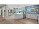 Modern kitchen with white cabinetry, a blue backsplash, and a beautiful waterfront view at 243 Hermosita Dr, St Pete Beach, FL 33706