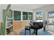 Bright living room featuring a black piano, waterfront view, and unique boat shelf at 243 Hermosita Dr, St Pete Beach, FL 33706