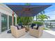 Inviting outdoor patio features comfortable seating, shade umbrella, and tranquil waterfront views at 243 Hermosita Dr, St Pete Beach, FL 33706