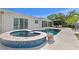 An expansive pool area with a connected spa and a comfortable outdoor seating area at 243 Hermosita Dr, St Pete Beach, FL 33706