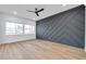Bedroom features wood-look floors, modern accent wall, and lots of natural light at 2608 W Columbus Dr # 3, Tampa, FL 33607