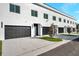 Modern townhomes with dark garage doors and minimalist landscaping creating a sleek, uniform look at 2608 W Columbus Dr # 3, Tampa, FL 33607