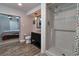 Bathroom featuring a dark vanity with granite countertop, a tiled shower, and access to the bedroom at 2933 Stratford Dr, Largo, FL 33771