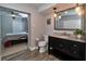 Bathroom featuring a dark vanity with granite countertop, a framed mirror, and modern pendant lighting at 2933 Stratford Dr, Largo, FL 33771