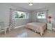 Bedroom featuring large windows, patterned curtains, and a comfortable bed with a side table at 2933 Stratford Dr, Largo, FL 33771