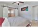 Bright bedroom featuring colorful wall art, a ceiling fan, and barn door access to the en-suite bathroom at 2933 Stratford Dr, Largo, FL 33771