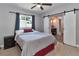 Cozy bedroom featuring a ceiling fan, a comfortable bed, and barn door access to the en-suite bathroom at 2933 Stratford Dr, Largo, FL 33771