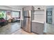 Kitchen featuring stainless steel fridge, gray cabinets, and adjacent living area at 2933 Stratford Dr, Largo, FL 33771