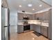 Contemporary kitchen featuring stainless steel appliances, stylish gray cabinets, and light countertops at 2933 Stratford Dr, Largo, FL 33771