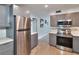 Updated kitchen with stainless steel refrigerator, gray cabinetry, quartz countertops, and mosaic backsplash at 2933 Stratford Dr, Largo, FL 33771